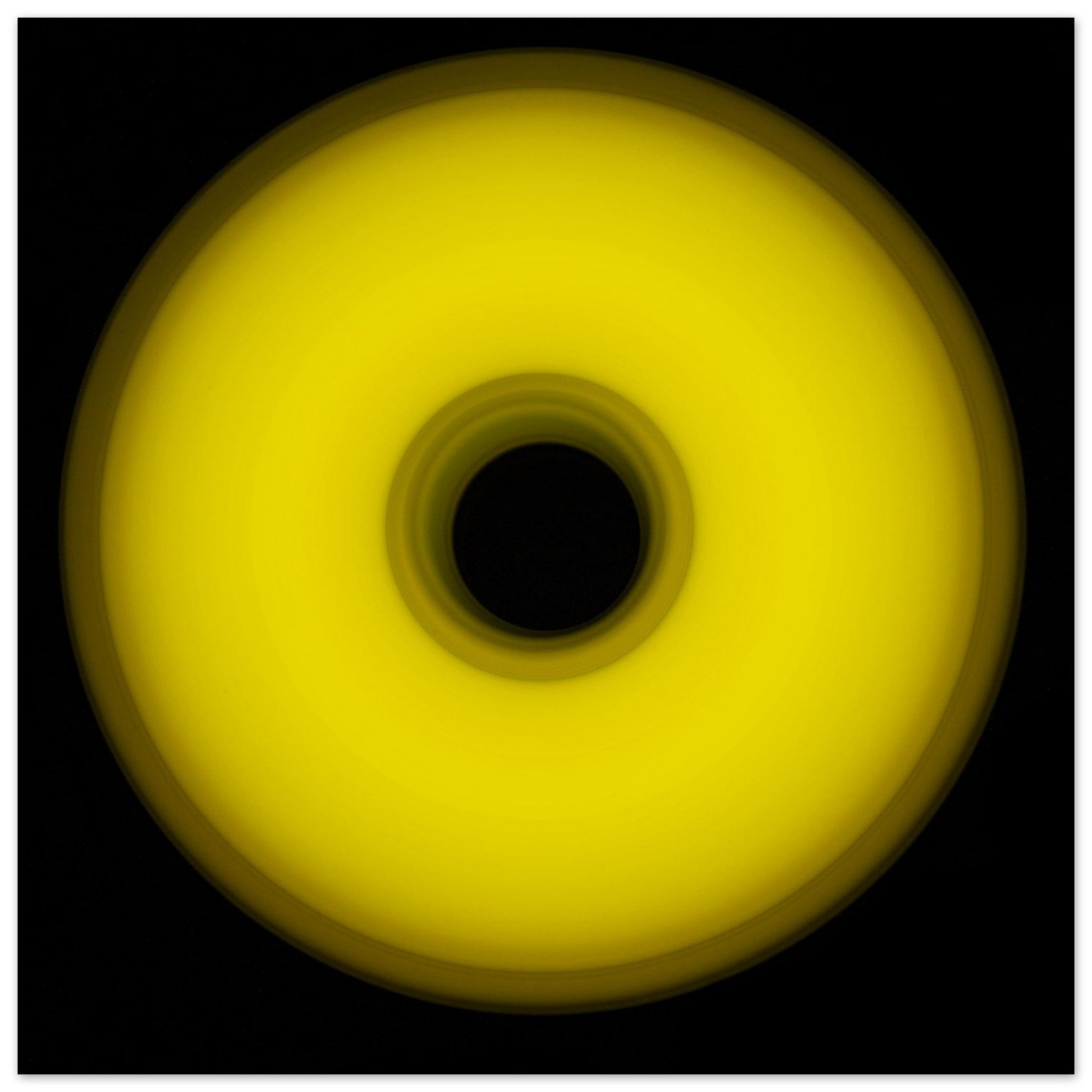 A circular yellow ring that gradients from bright yellow at the edges to olive green toward the dark center hole.