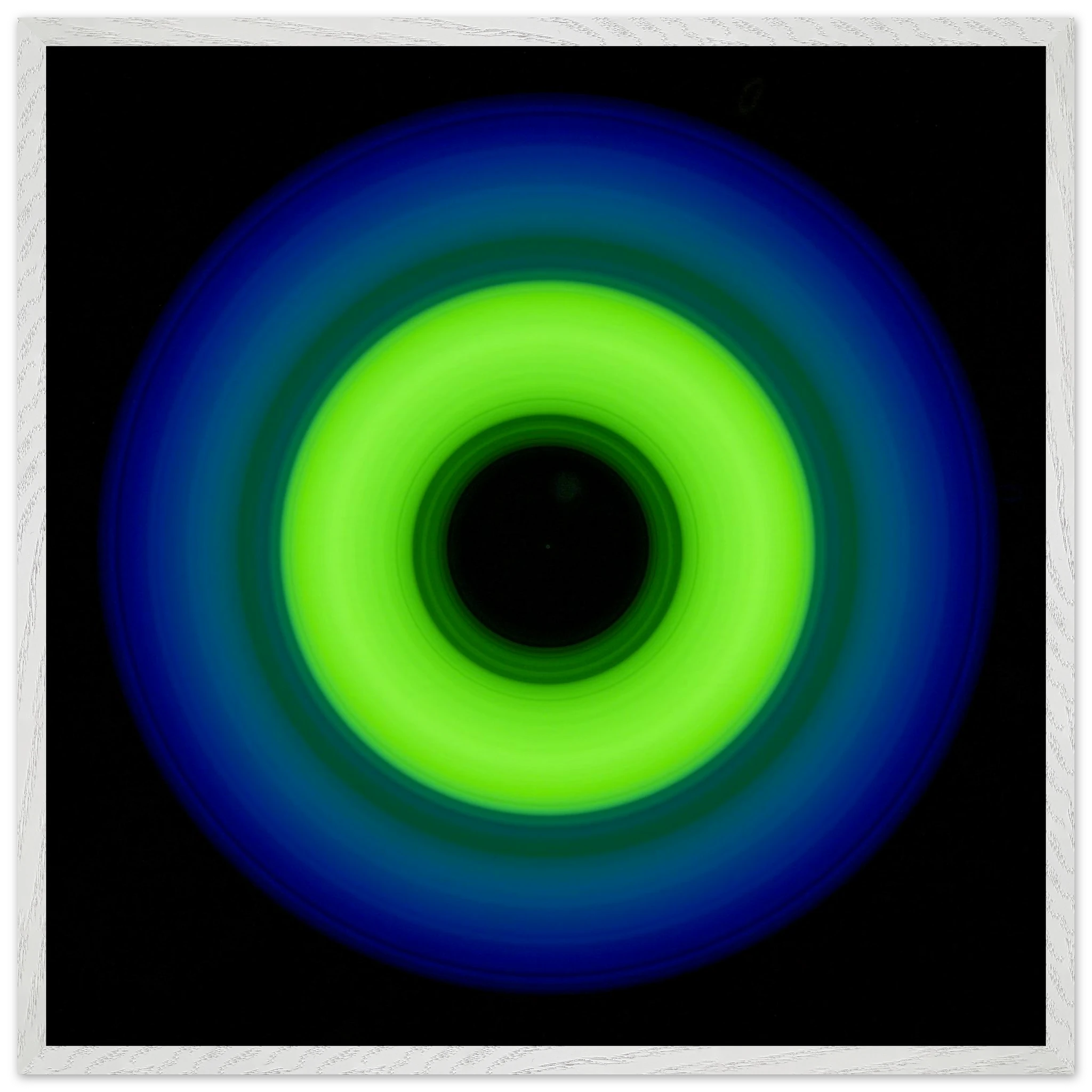 A circular ring shape with bright lime green center transitioning through teal to cobalt blue outer edge with black center void.