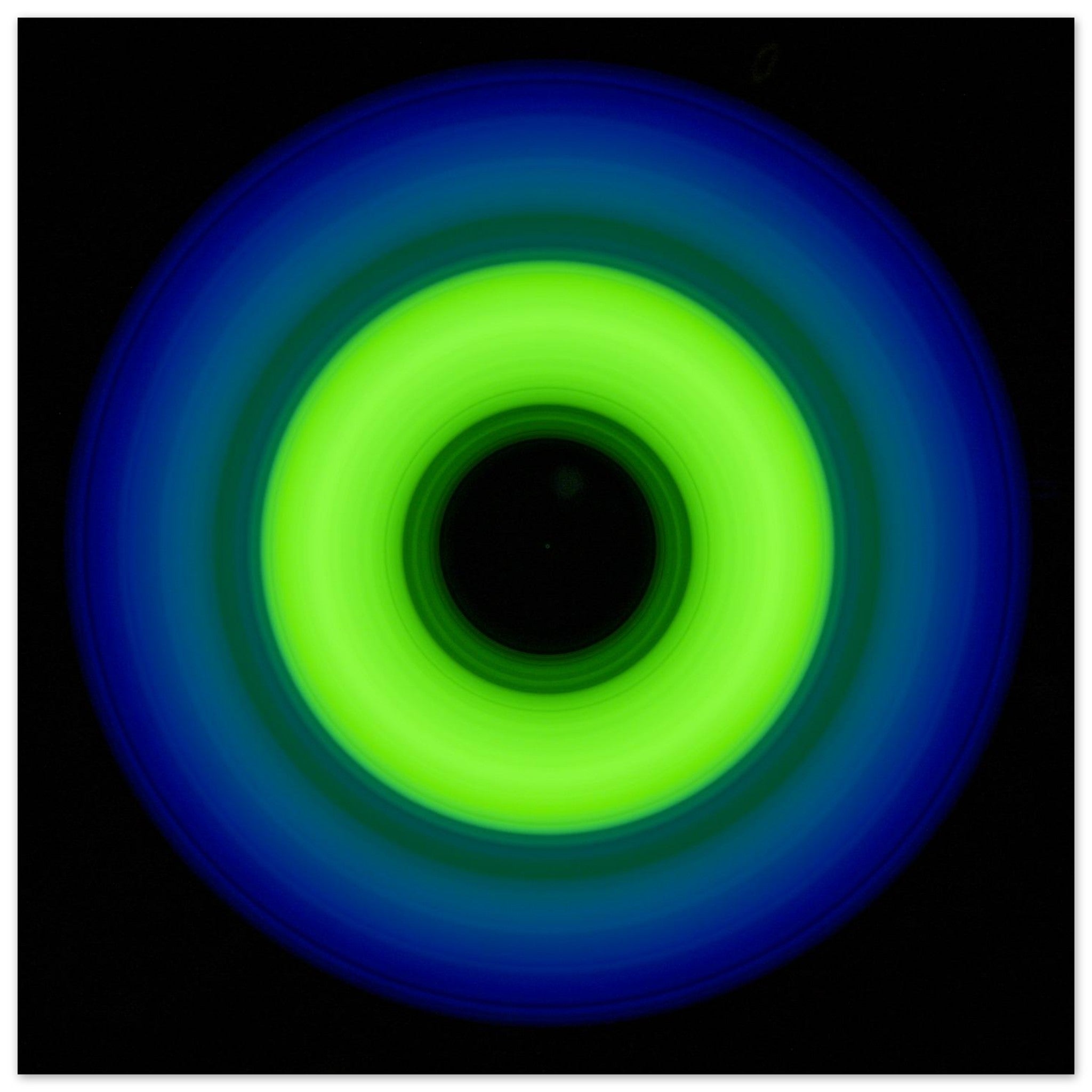 A circular ring shape with bright lime green center transitioning through teal to cobalt blue outer edge with black center void.
