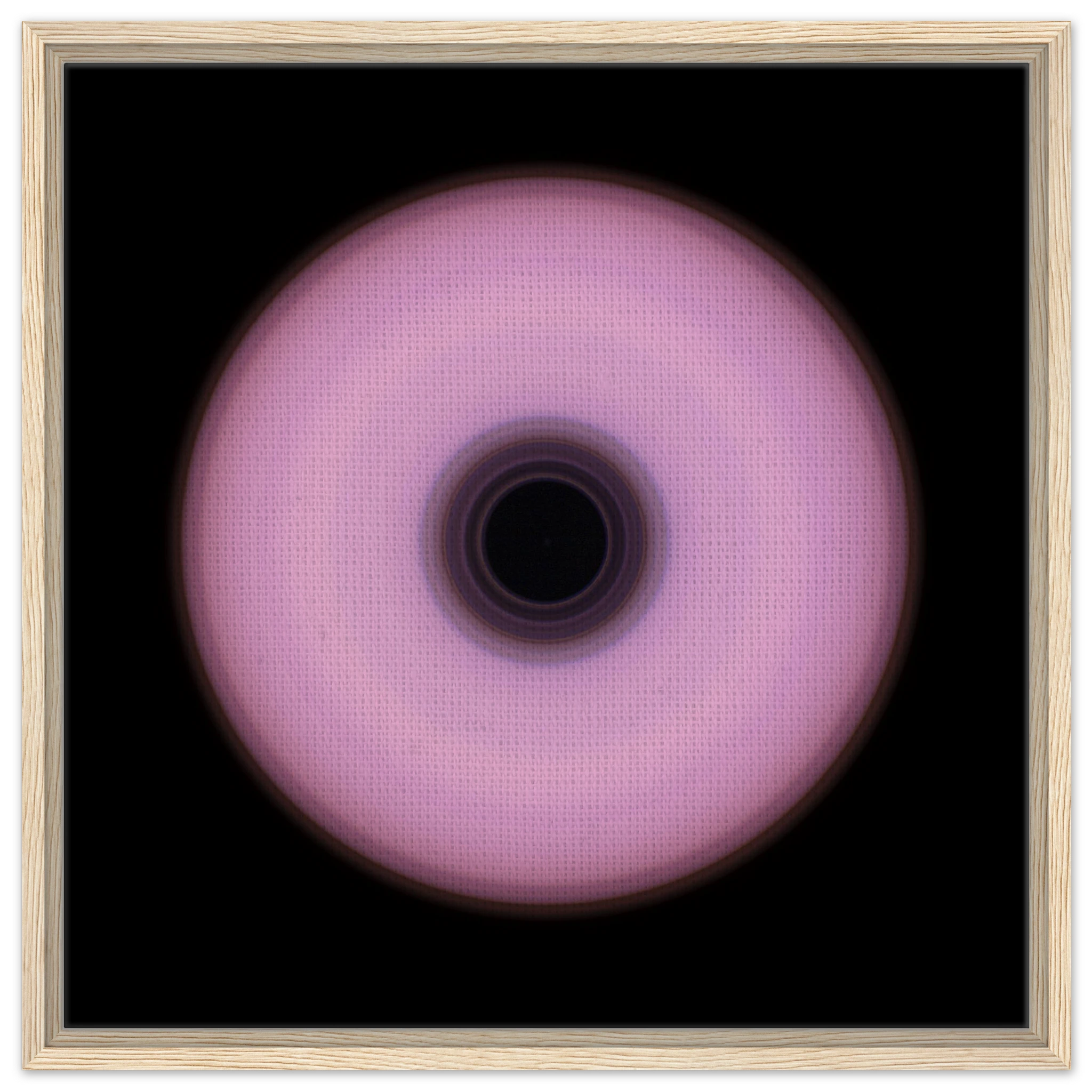 A circular ring with soft pink outer area and concentric bands in the center transitioning from deep violet to black.