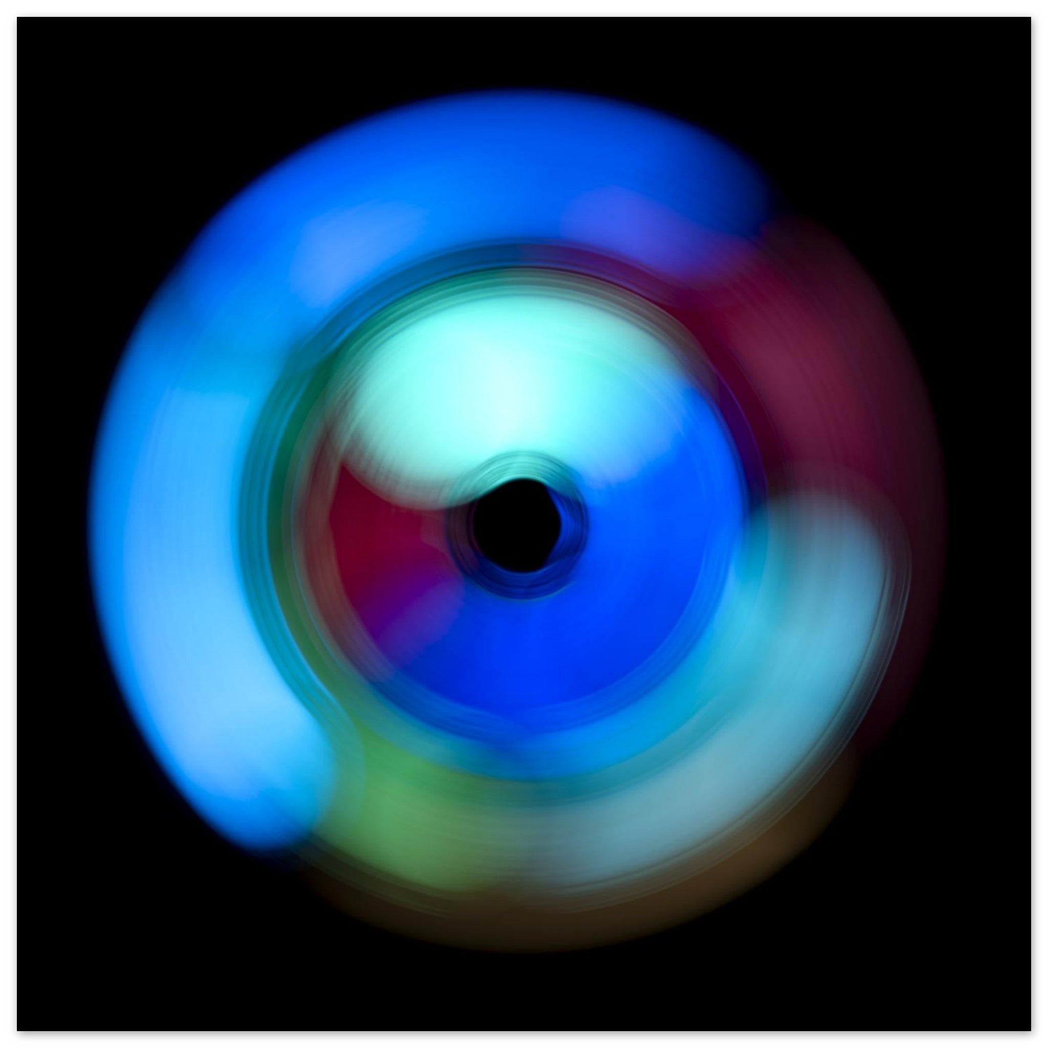 A circular radial pattern with electric blue outer regions, magenta middle zones, and pale green accents surrounding a small dark center circle.