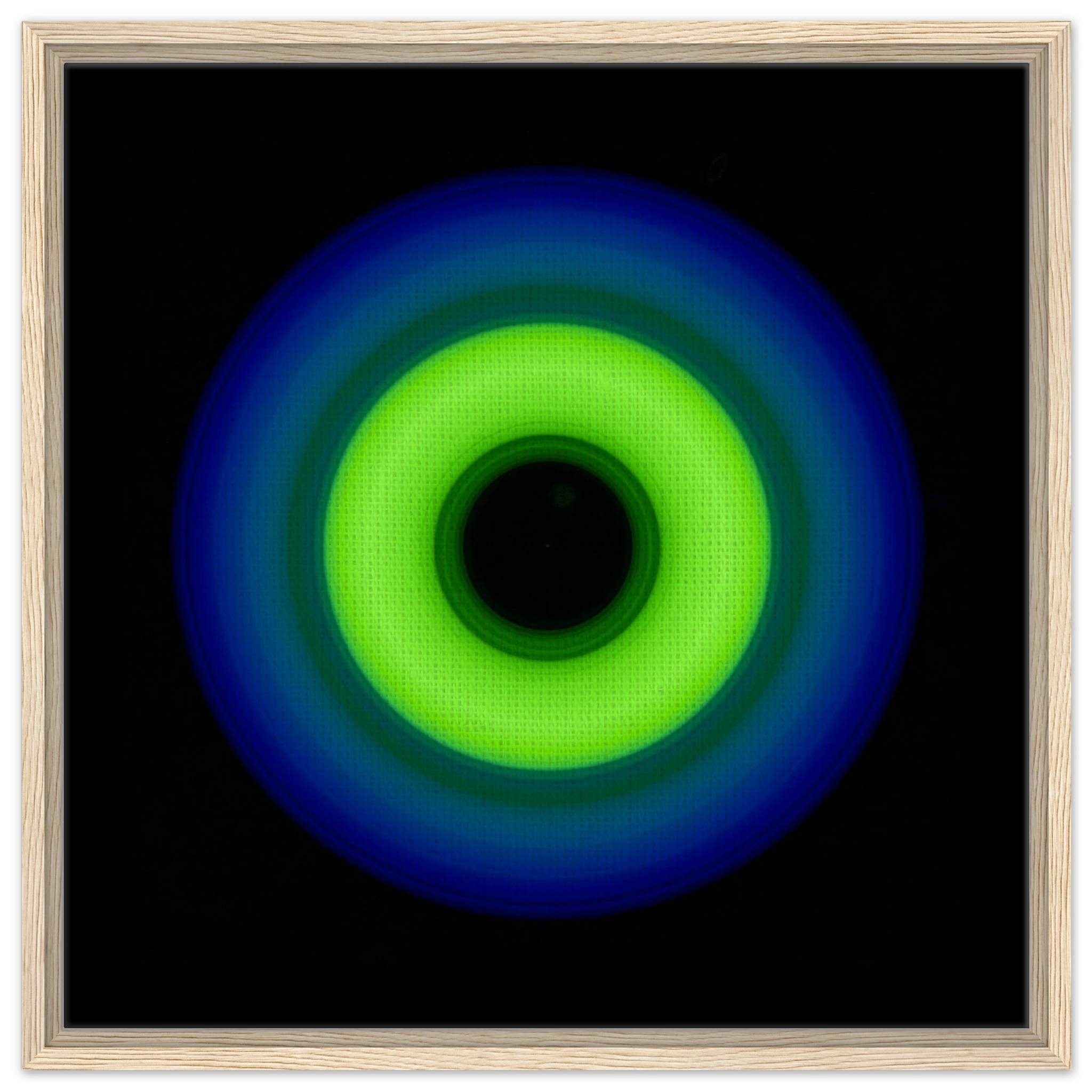 A circular ring shape with bright lime green center transitioning through teal to cobalt blue outer edge with black center void.