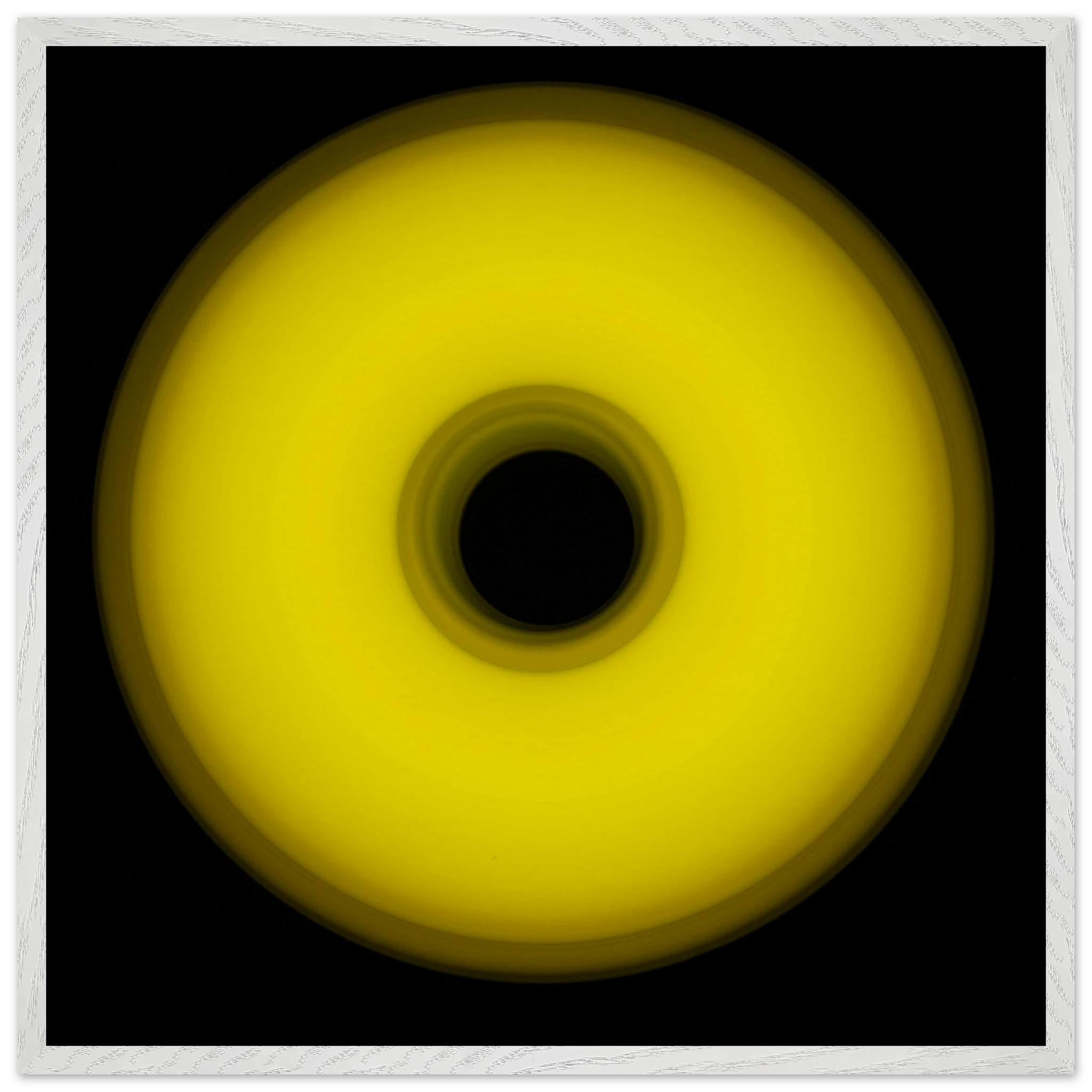 A circular yellow ring that gradients from bright yellow at the edges to olive green toward the dark center hole.